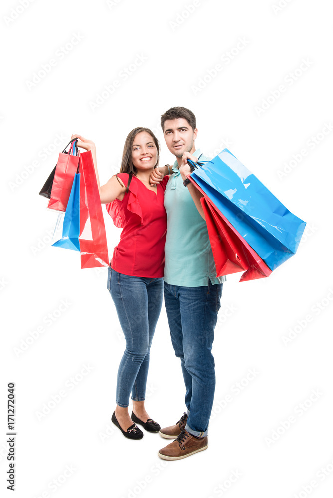 Full body of attractive couple smiling carrying shopping bags