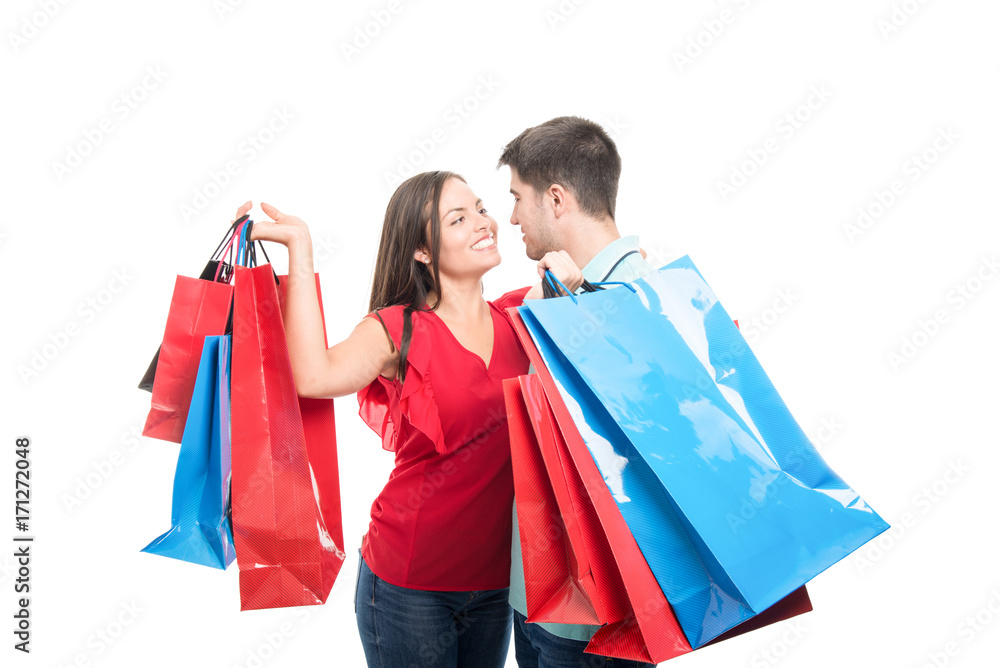 Attractive couple smiling carrying shopping bags