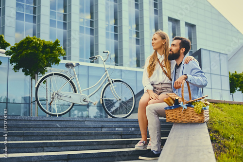 A couple sits on a step with picnic basket. © Fxquadro