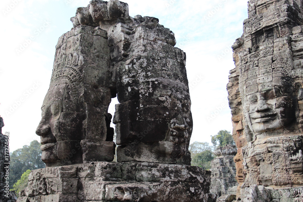 Fototapeta premium The ruins of an old temple with stone heads and faces in Cambodia