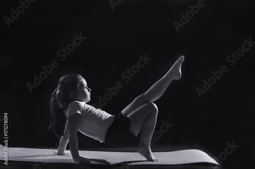 Little caucasian female gymnast in reversed table pose