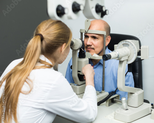 female ophthalmologist and mature patient checking eyesight in clinic