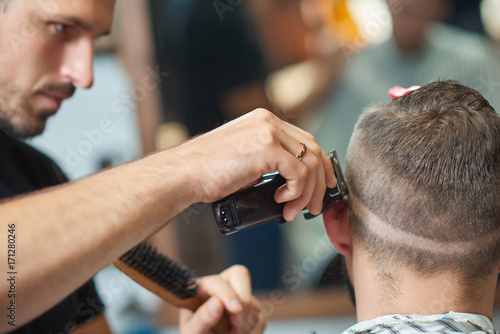Cropped close up of a professional barber working giving a haircut to a man.