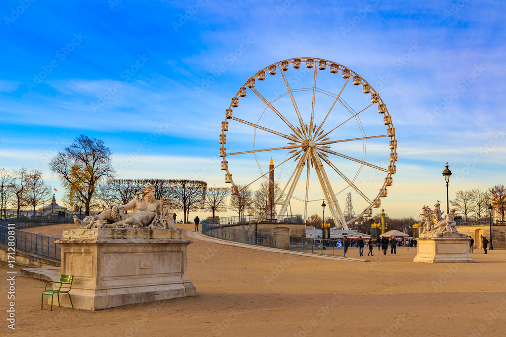 PARIS, FRANCE : Walking path in famous Tuileries Garden (Jardin des Tuileries) to The giant Ferris Wheel (Grande Roue) is set up on Place de la Concorde Summer sunny day.