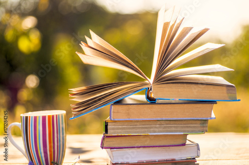 Open book on wooden table on natural background. Soft focus