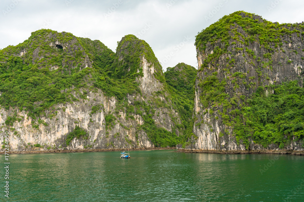 Halong Bay islands view with fishing boat