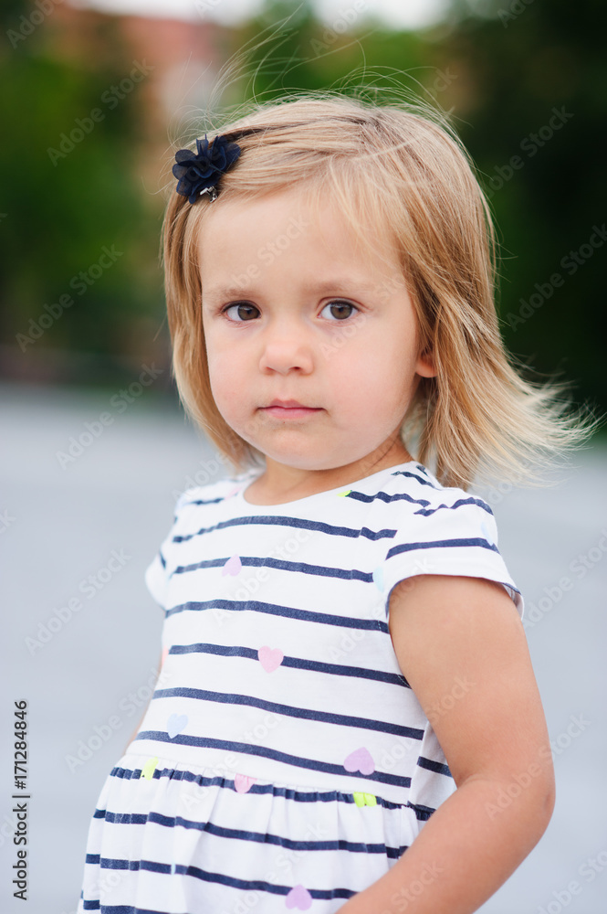 Portrait of a two year old girl in a striped dress. Portrait of a two year old girl in a striped dress.