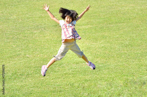 芝生広場でジャンプする女の子 © hanapon1002