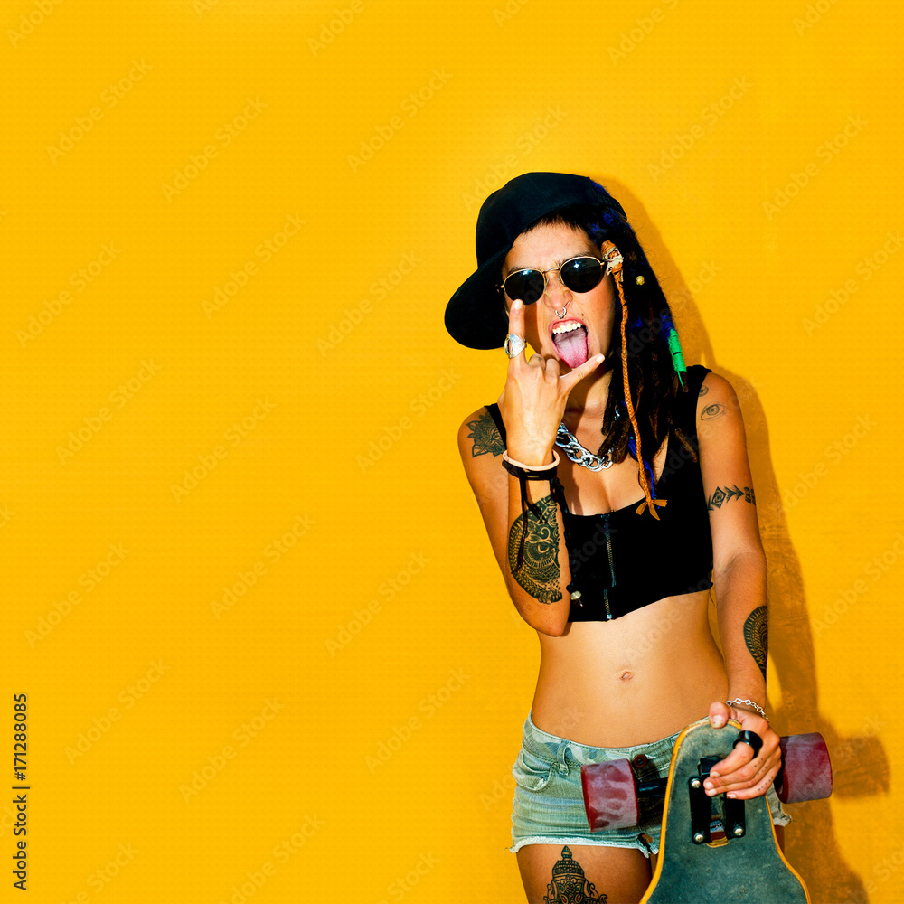 Alternatives Girl with dreadlocks and tattoos. Skateboarding. Urban style  Stock Photo | Adobe Stock