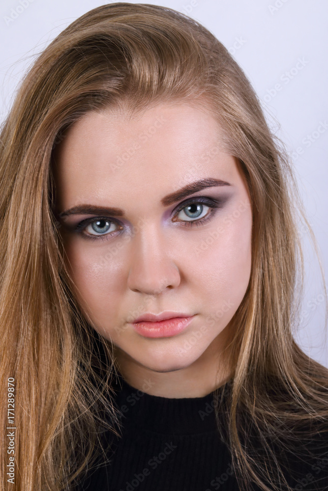 Young blonde in black clothes poses in white studio, close up Young blonde in black clothes poses in white studio, close up