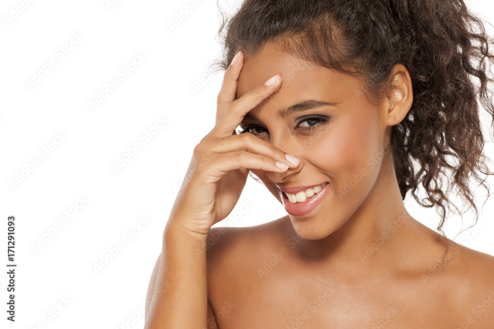 portrait of a smiling and shy young dark-skinned woman on a white background