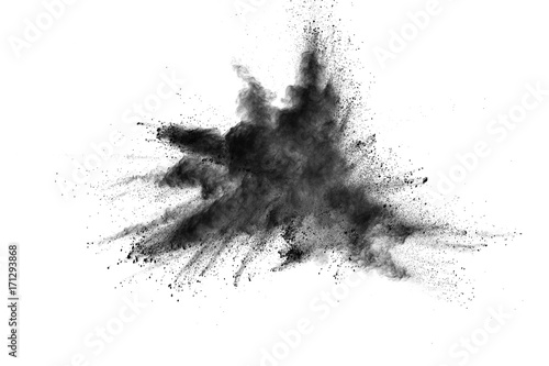 Black powder explosion. Closeup of black dust particles explode isolated on white background.