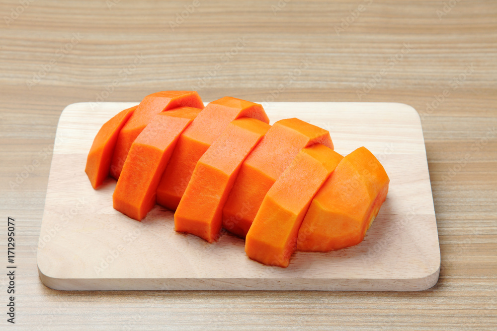 peeled papaya on the wooden cutting board peeled papaya on the wooden cutting board
