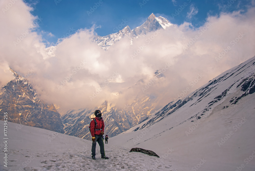 Man hiker walking in the mountains, freedom and happiness, achievement in mountains. Himalayas, Everest Base Camp trek, Machapuchare mountain Background.