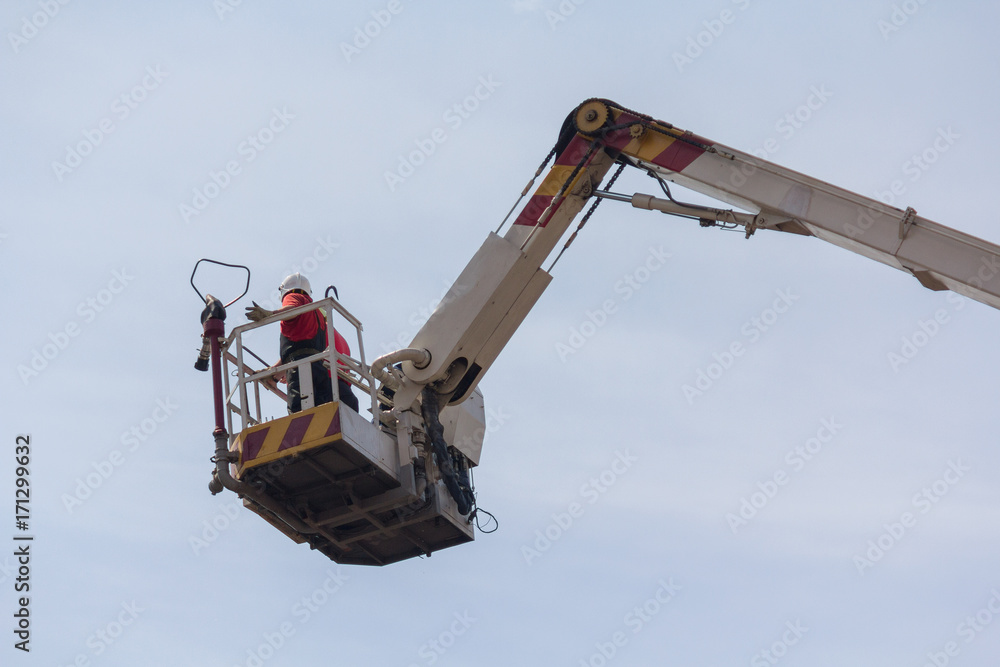 Fireman in a lifting basket against the sky Fireman in a lifting basket against the sky