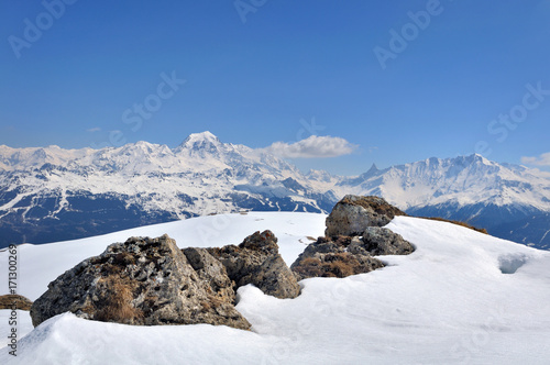 rochers dans la neige et sommets sous ciel bleu