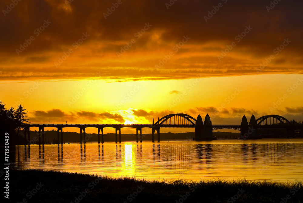 Brilliant orange sunset over Florence Historic Bridge; Oregon coast
