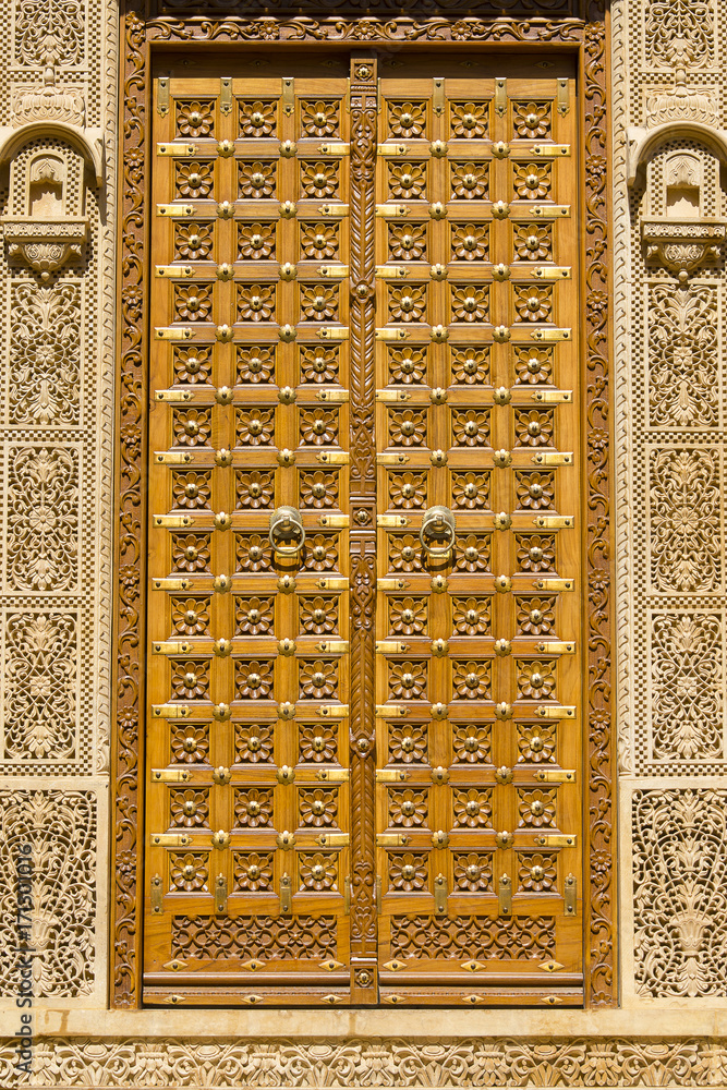 Wooden door and ornament on wall of palace in Jaisalmer fort, India.