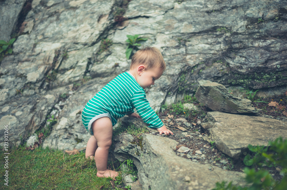 Little baby exploring nature by rocks