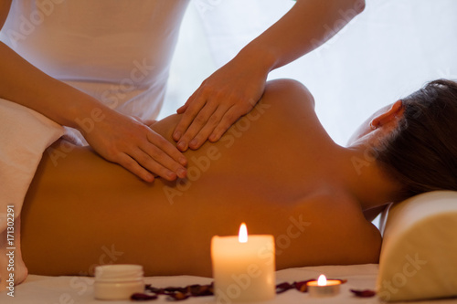 Back massage woman enjoying massage indoors - close up
