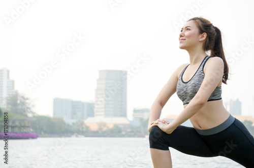 Asian woman people warm up for running and yoga / lunges in park for health with happiness fitness