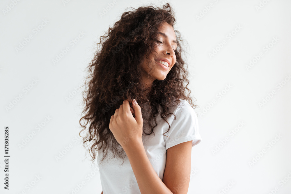 Portrait of a smiling pretty girl with curly hair looking away Portrait of a smiling pretty girl with curly hair looking away
