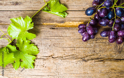 Purple grape on rustic wooden background