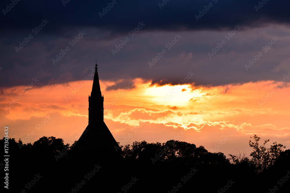 Obraz premium Sunset silhouette of church tower at sunset