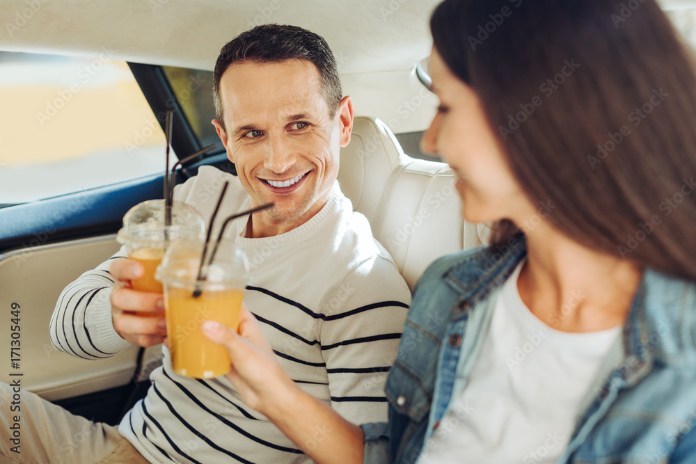 Joyful good looking man drinking juice with his girlfriend Joyful good looking man drinking juice with his girlfriend