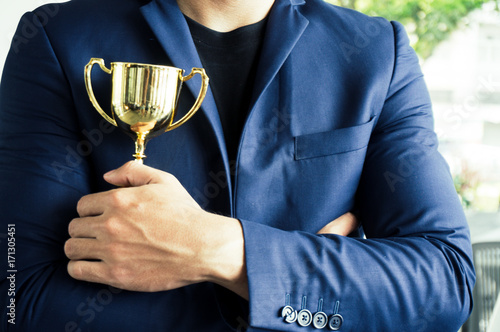 Businessman to be winner holding award trophy with successful and achievement