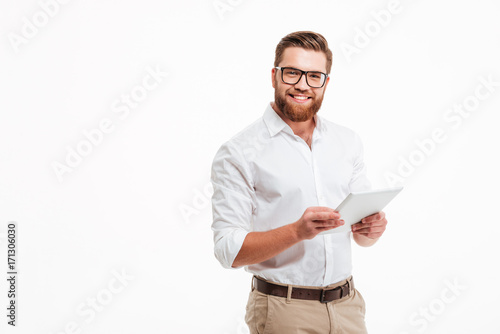 Obraz na płótnie Happy young bearded man using tablet computer.