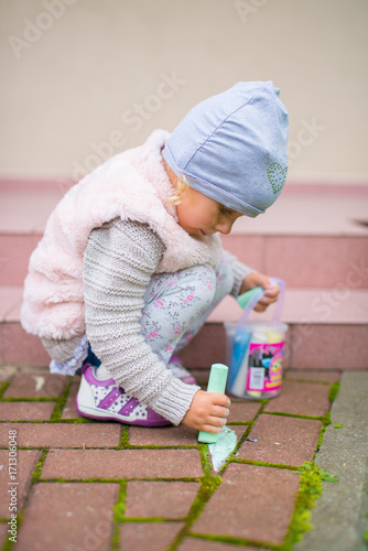 Dziewczynka malująca kredą na chodniku