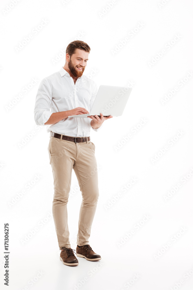 Handsome young bearded man using laptop.