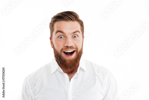 Happy young bearded man standing over white wall