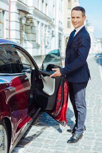 Wallpaper Mural Delighted good looking man inviting to sit into his car Torontodigital.ca