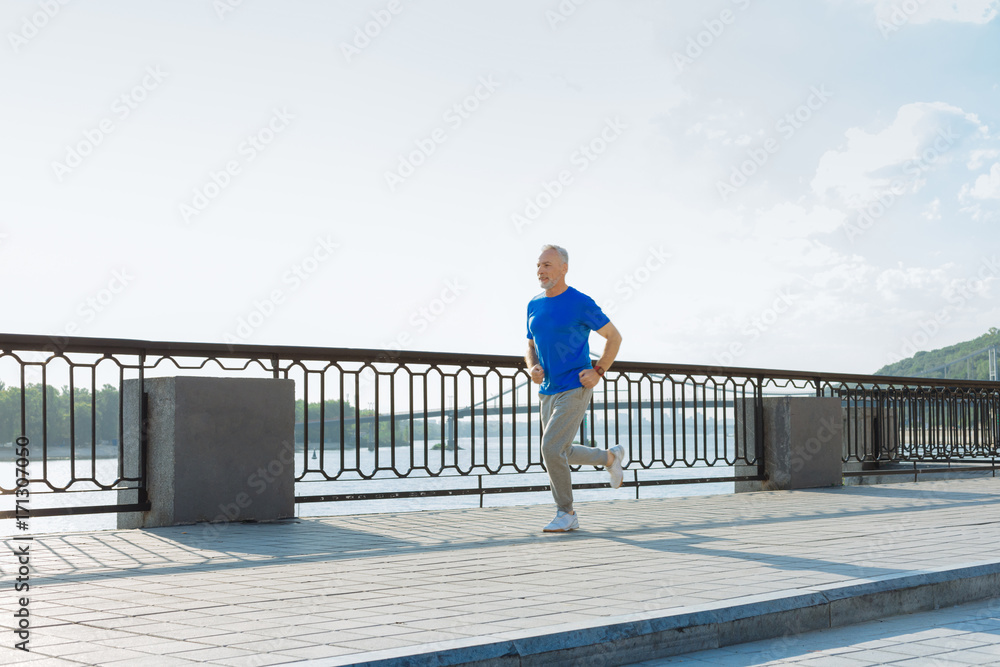 Athletic senior man jogging in the morning