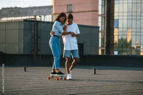 young woman learning to ride skateboard