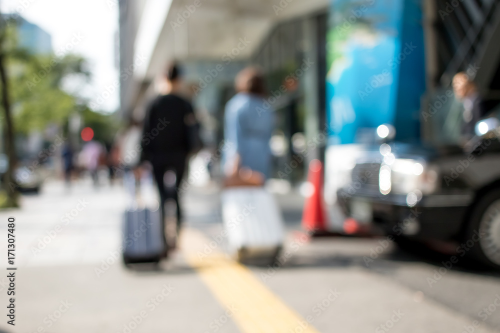People with Suitcases Walking in Holiday at the City of Nagoya in Japan; Blur Background with Bokeh Effects
