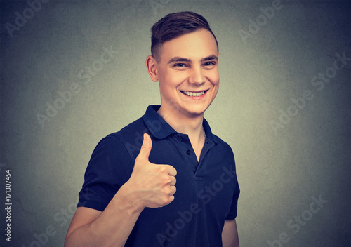 Happy young handsome man showing thumbs up