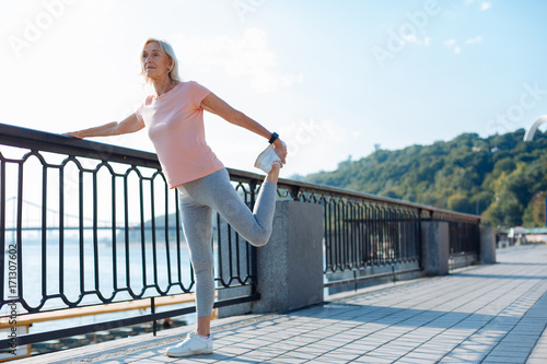 Athletic woman stretching her leg on the bridge