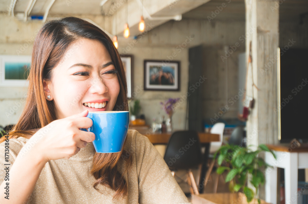 Asian woman drink coffee with smile in coffee shop feeling happy and relax Asian woman drink coffee with smile in coffee shop feeling happy and relax