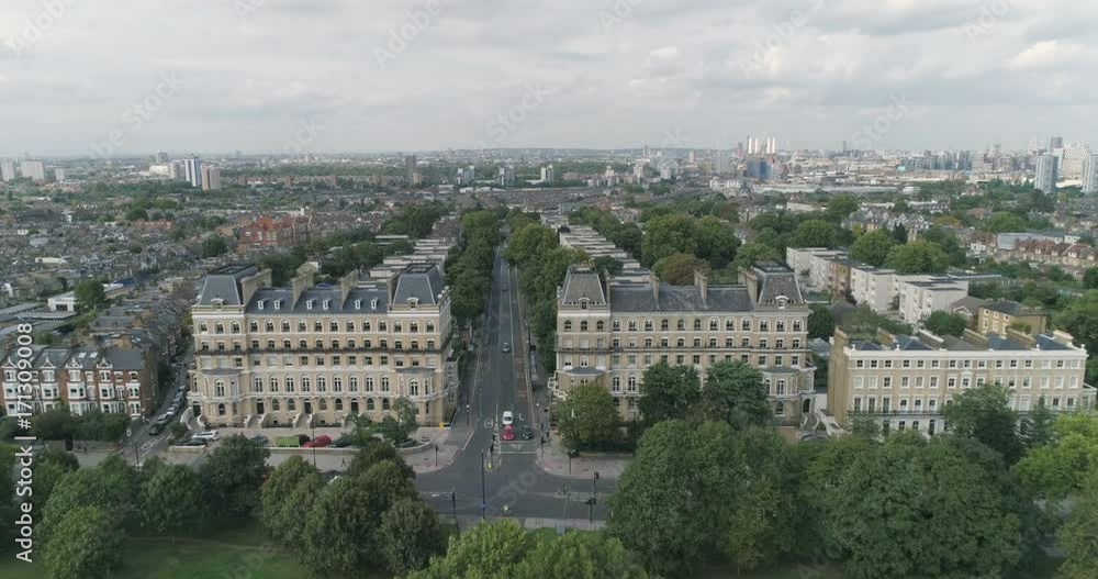 Aerial pull out view from a residential victorian village in London revealing a tree lined path in a park Aerial pull out view from a residential victorian village in London revealing a tree lined path in a park