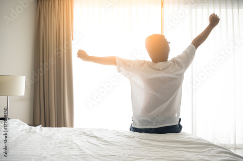 Man wake up and stretching in morning with sunlight