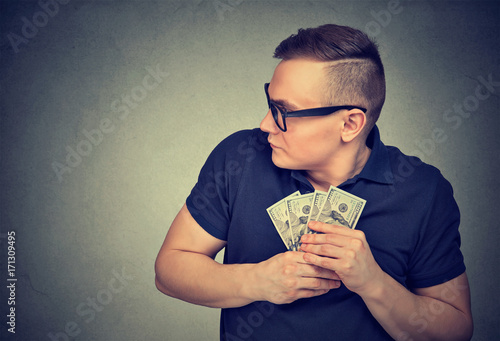 Tablou canvas Suspicious greedy man grabbing money