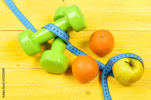 weightlifting concept, dumbbells weight with measuring tape, fruit