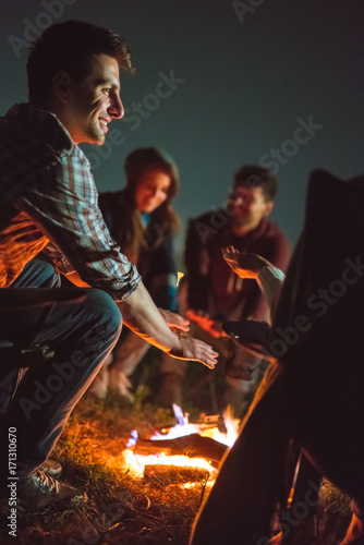 The smile people warming hands near the bonfire. night time