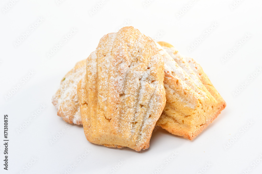 Freshly baked Madeleine cookies sprinkled with sugar powder
close-up on the table, petite madeleine isolated on white
background. Freshly baked Madeleine cookies sprinkled with sugar powder
close-up on the table, petite madeleine isolated on white
background.