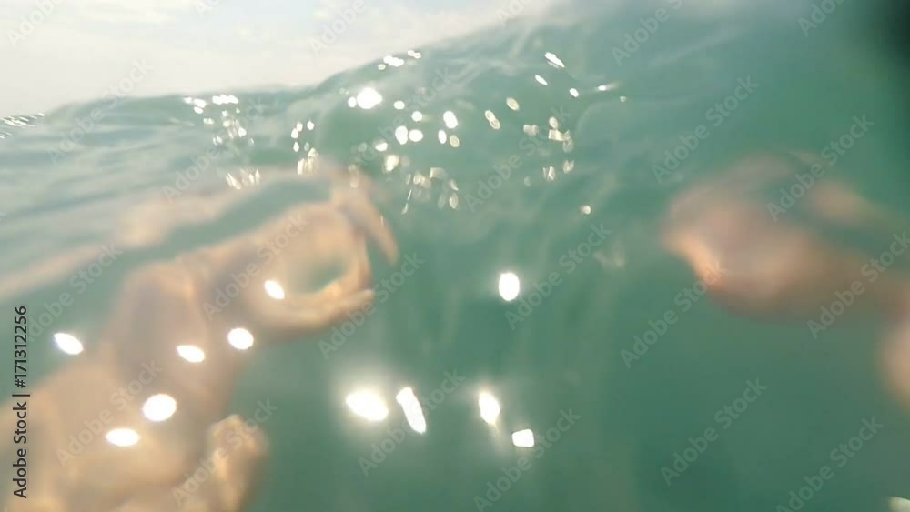 Man swimming in sea water POV