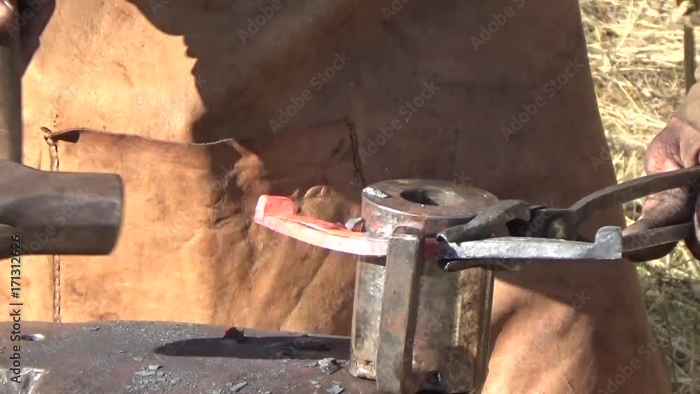 The blacksmith works with a hammer The blacksmith works with a hammer