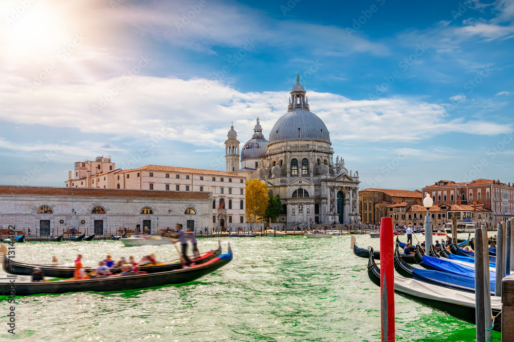 Fototapeta premium Basilica di Santa Maria della Salute z przejeżdżającymi gondolami w Wenecji, Włochy